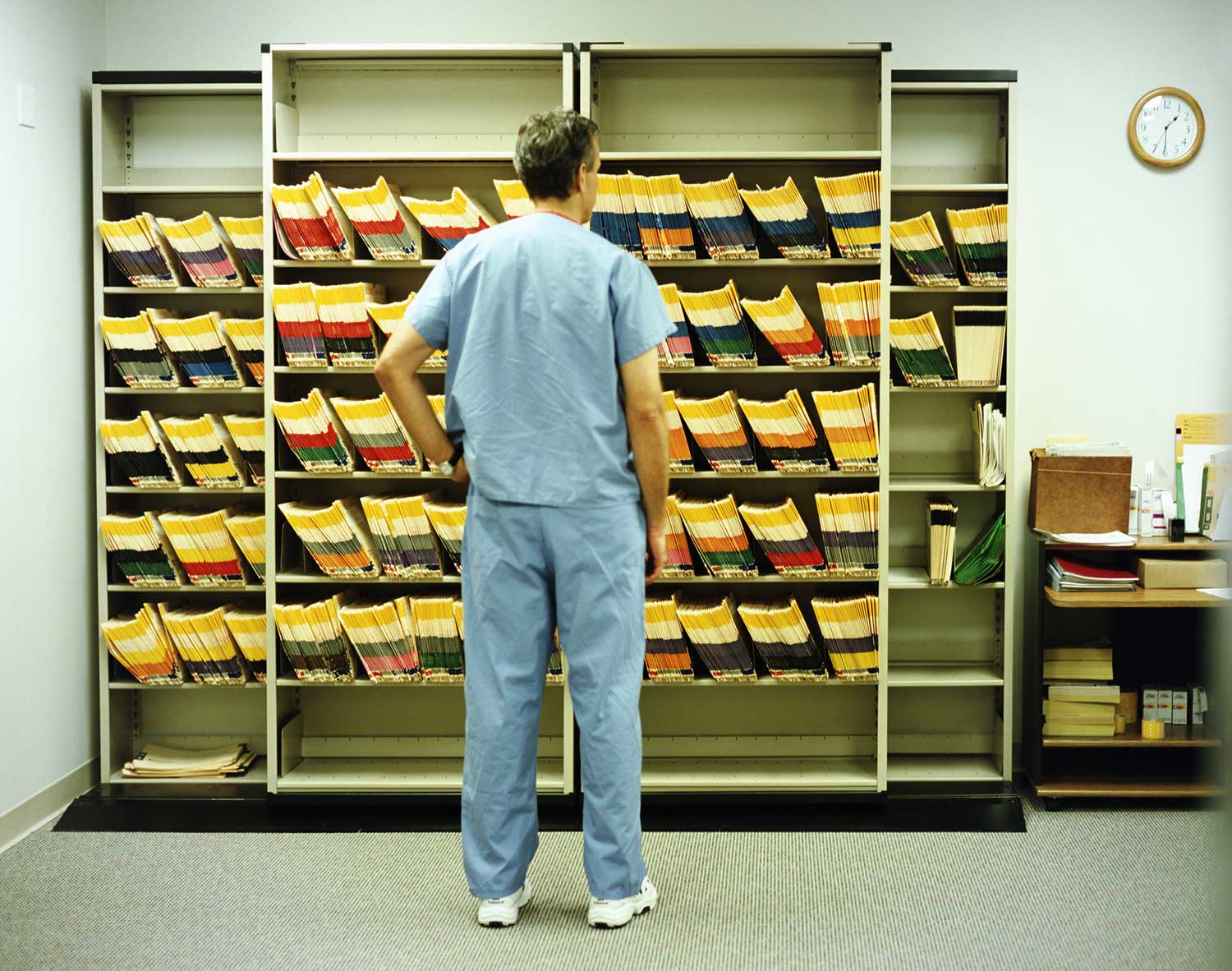 Doctor looking at shelves full of files